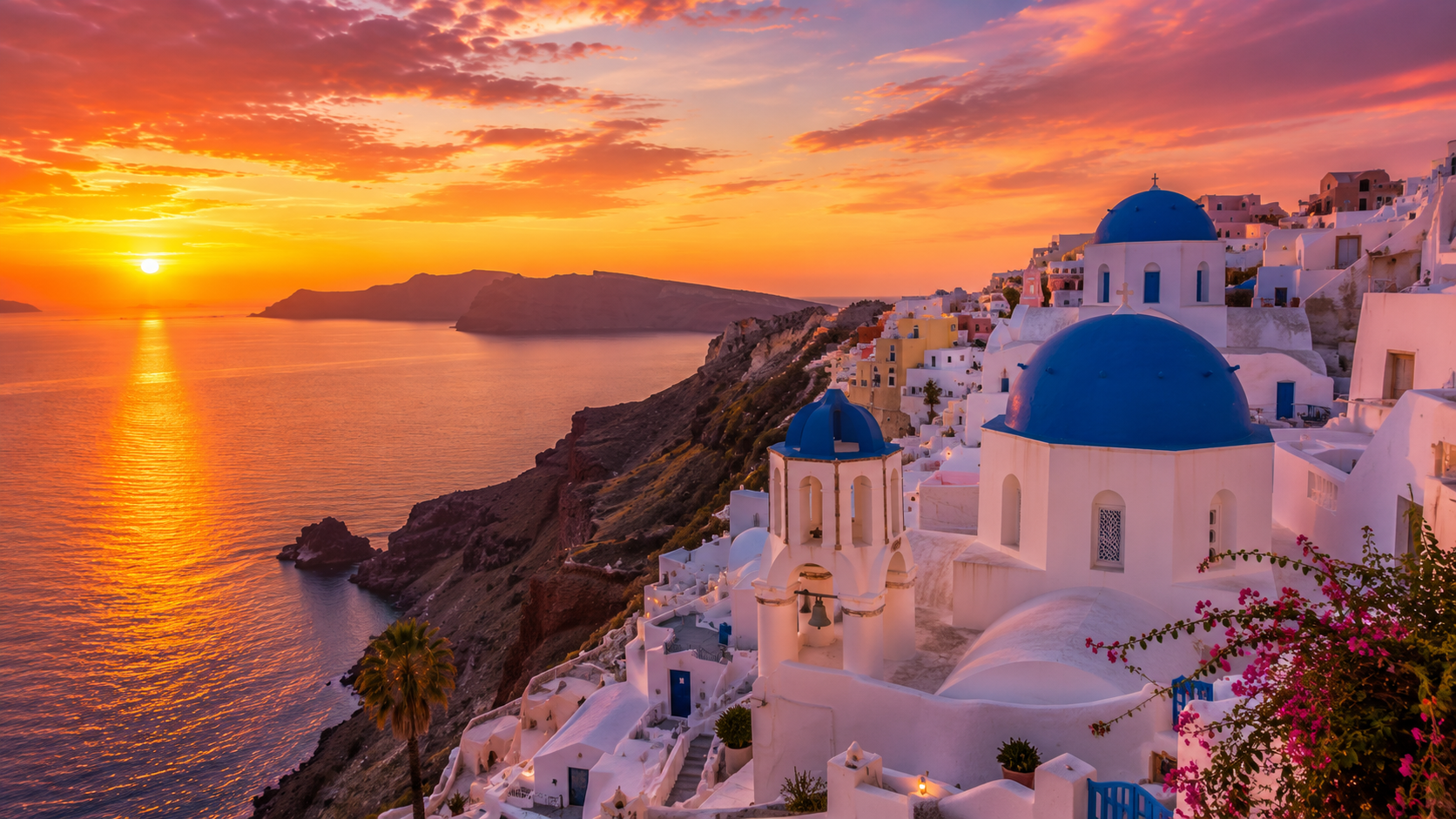 Sunset over Santorini, Greece, featuring whitewashed buildings, blue-domed churches, and panoramic views of the Aegean Sea beneath a vibrant orange sky.